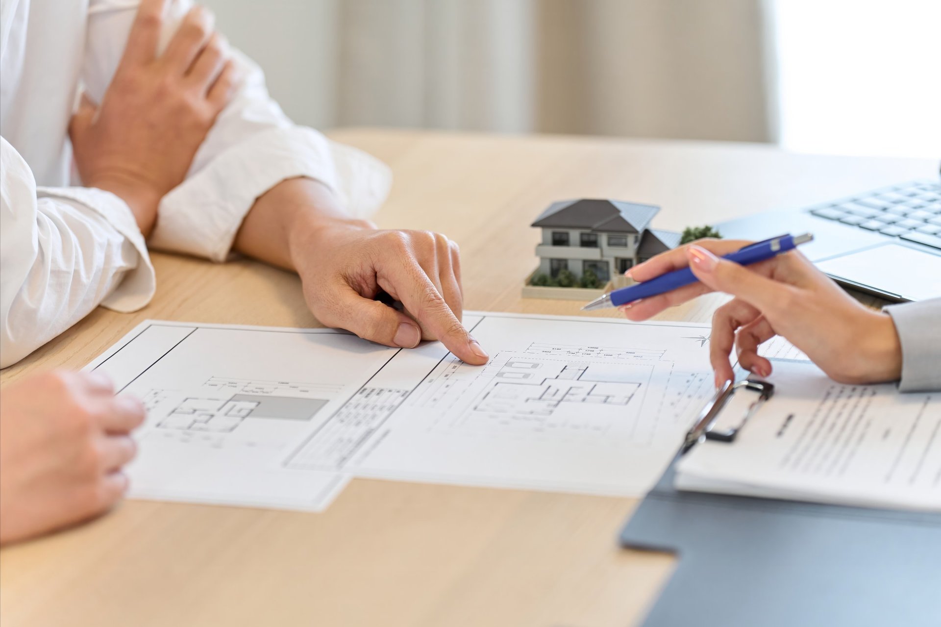 Parent discussing a floor plan with a young adult while reviewing a property