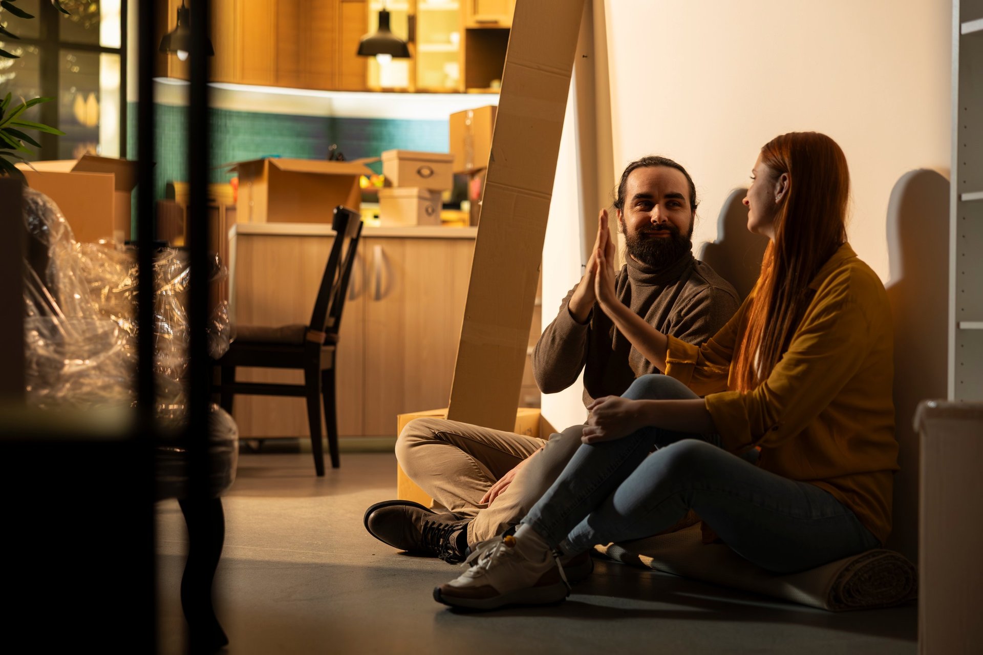 Young couple celebrating their completed home purchase while standing in their new house