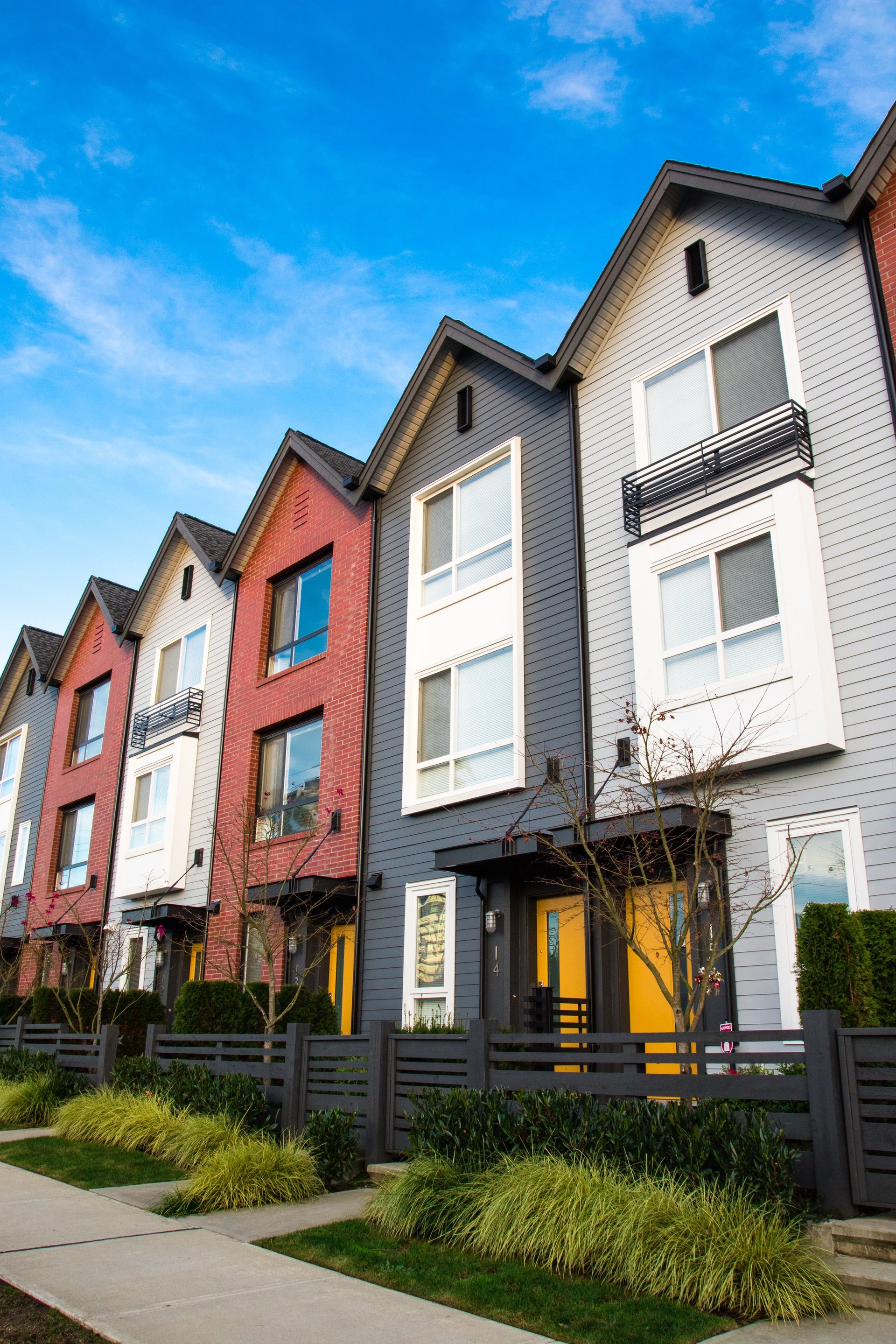 A row of new townhouses and condominiums in a residential neighborhood near a college campus